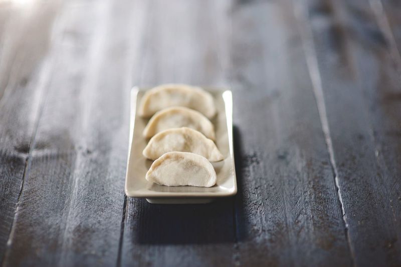 Close-up of dumplings in plate on wooden table