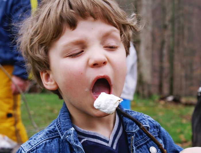 Close-up of boy having marshmallow outdoors