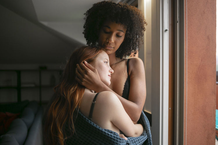 YOUNG WOMAN WITH MOTHER AND SON AT HOME