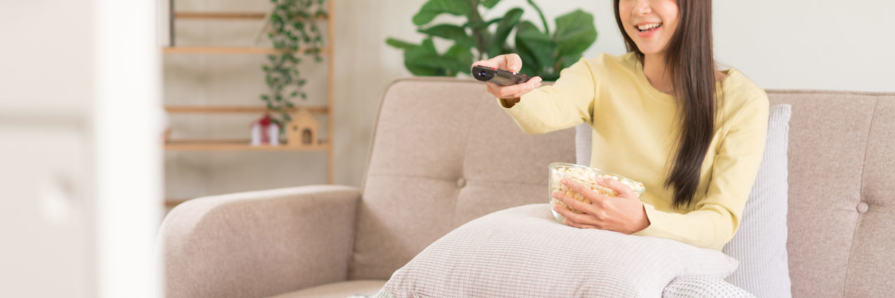 Young woman using mobile phone while sitting on sofa at home