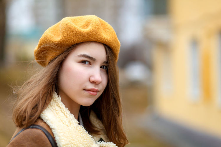 Close-up portrait of young woman wearing hat