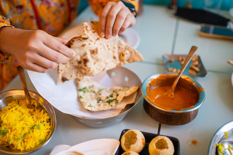 Cropped hand of person preparing food on table