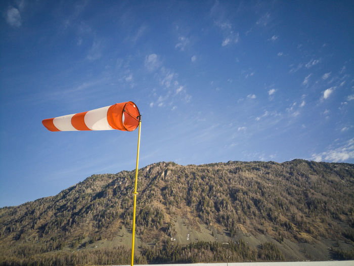 Scenic view of windsock against mountain and sky