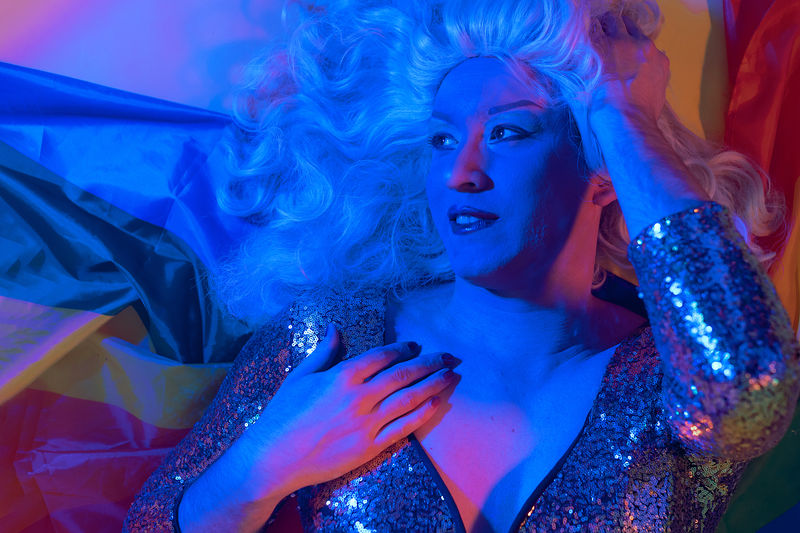 Portrait in blue neon light of a drag queen