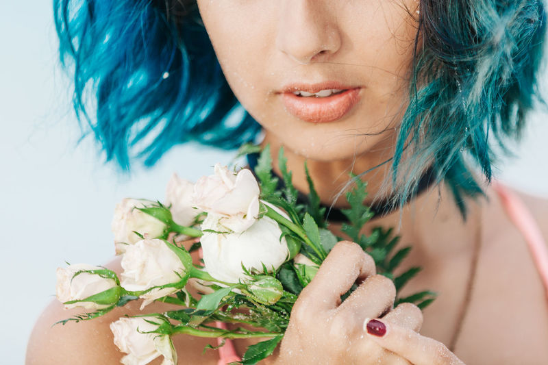 Close-up midsection of young woman holding white roses