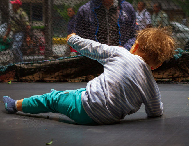 Rear view of boy playing on trampoline