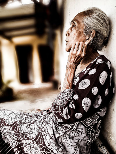 Senior woman sitting on corridor