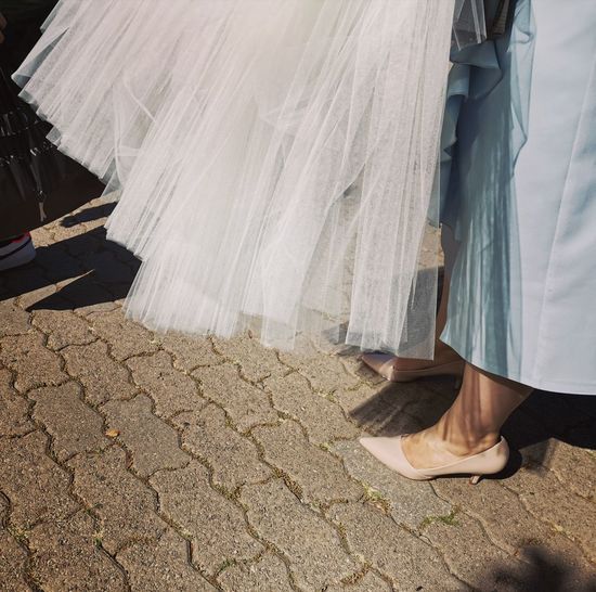 Low section of bride standing on footpath