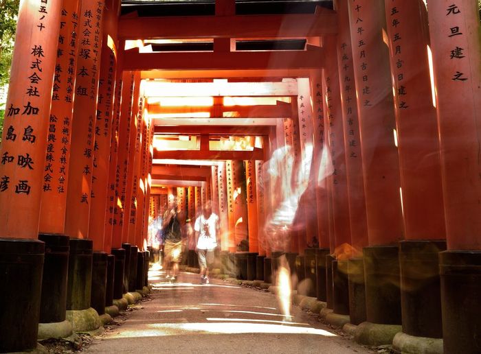 Multiple exposure of people walking in torii gate