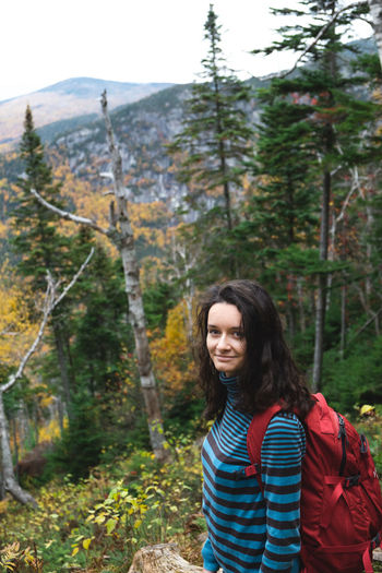 Portrait of smiling young woman hiking in forest