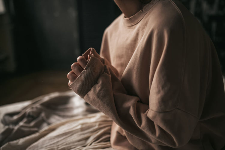 Midsection of man holding while sitting at home