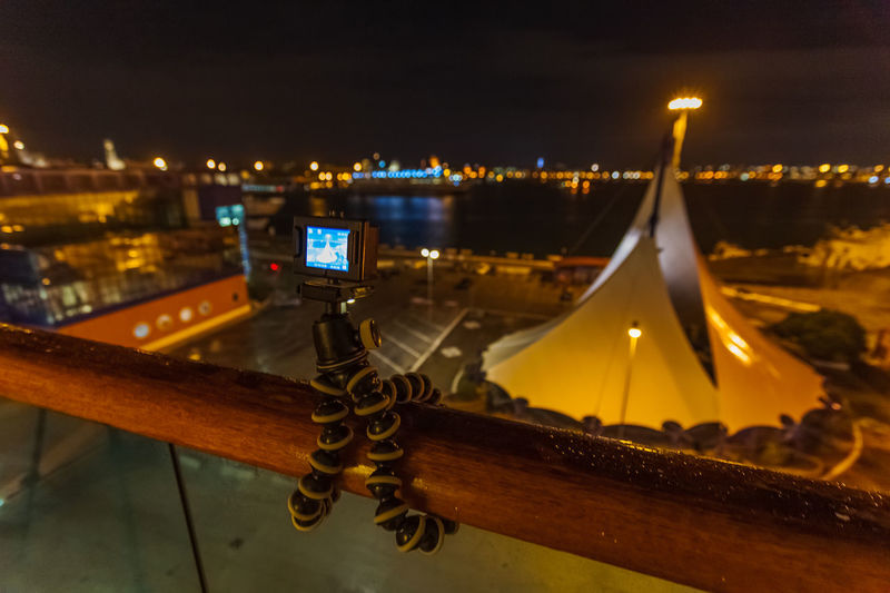 Action camera on tripod that takes over the port of bari at night from the balustrade of a ship
