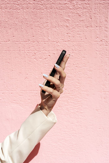 Cropped hand of woman using mobile phone