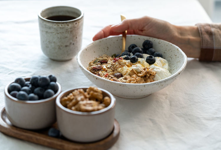 Eating healthy lifestyle breakfast with granola muesli and yogurt in bowl on white table background