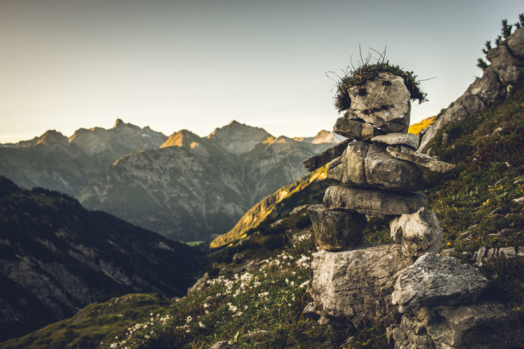 Close-up of rock against mountain range and sky