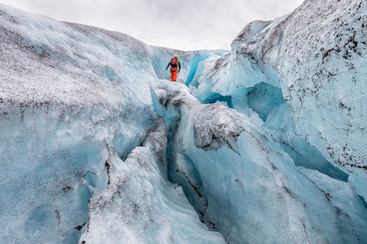Low angle view of hiker standing on snow formation