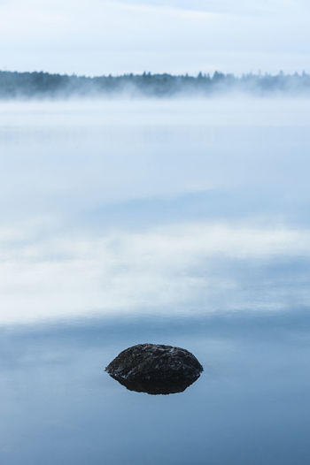 Stone lying in still and misty lake