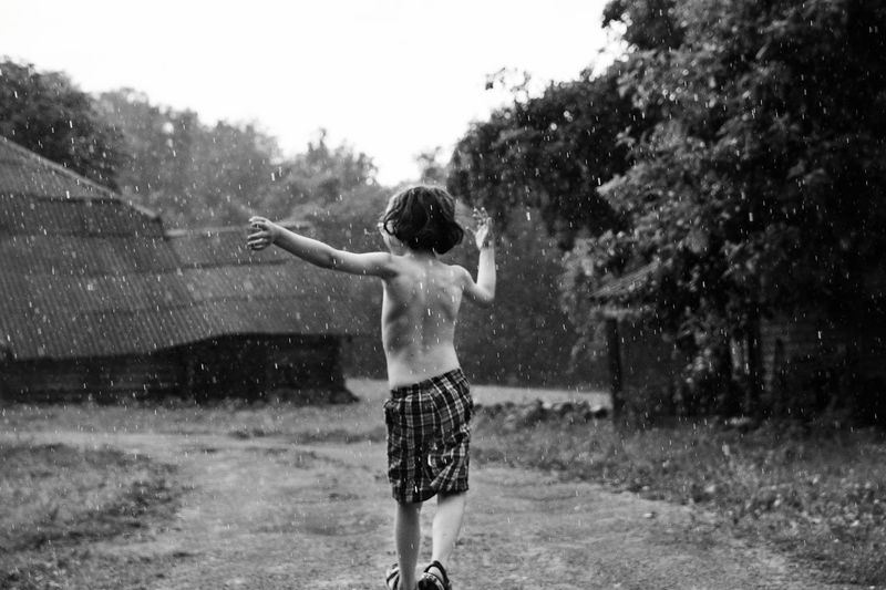 Rear view of a boy, running in the rain