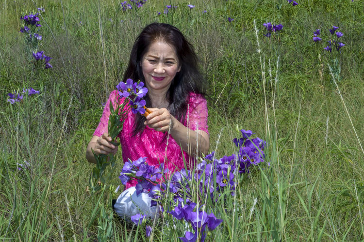 Portrait of a smiling woman with purple flower
