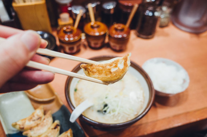 Close-up of hand holding food with chopsticks