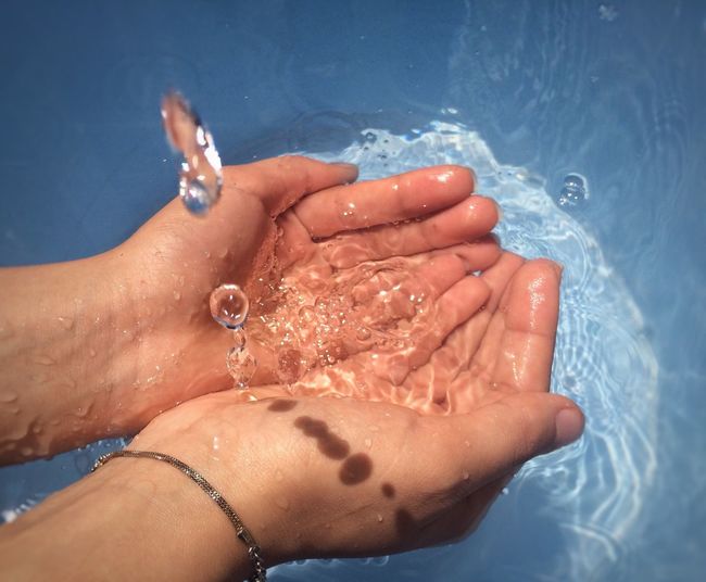 Cropped image of person holding water in cupped hands