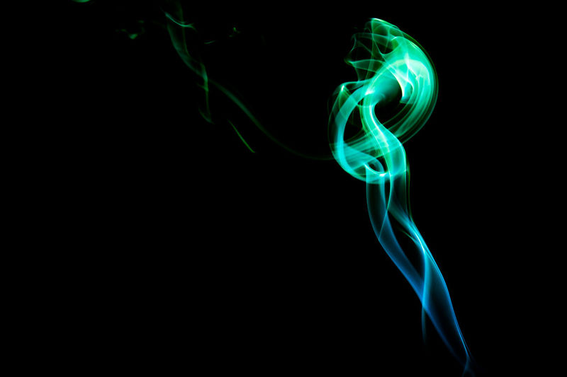 Close-up of blue and green smoke against black background