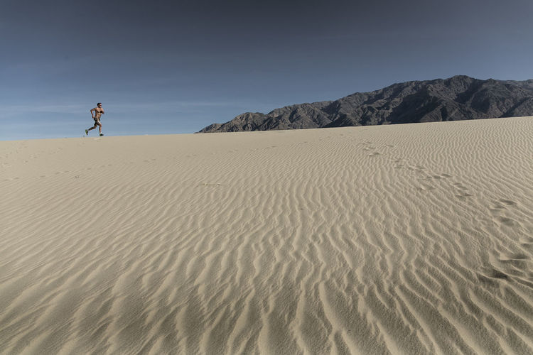 A man runs in the desert sand in death valley