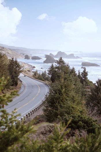 High angle view of coastal road amidst trees against sky