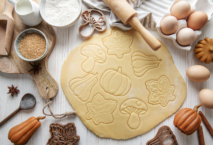 Baking cookies in the form of pumpkin and leaves. cozy autumn pastry. dough with cookie cutters.