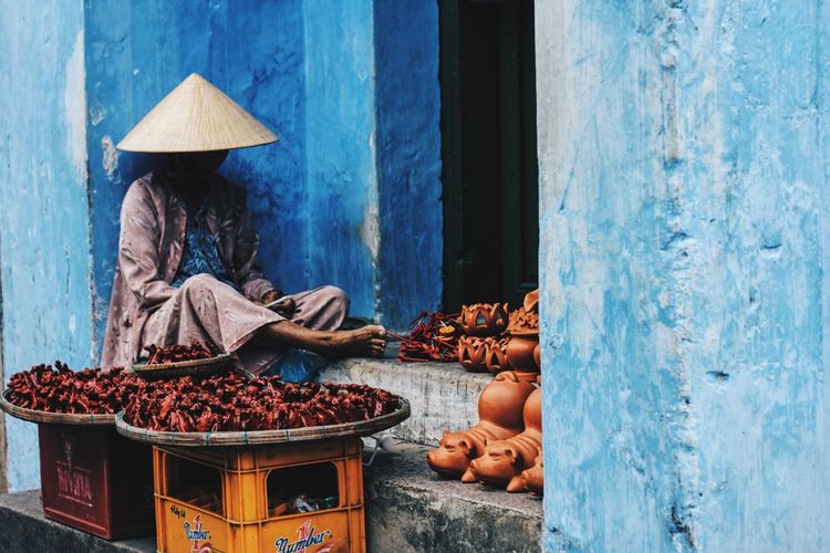 Vendor selling food while wearing asian style conical hat