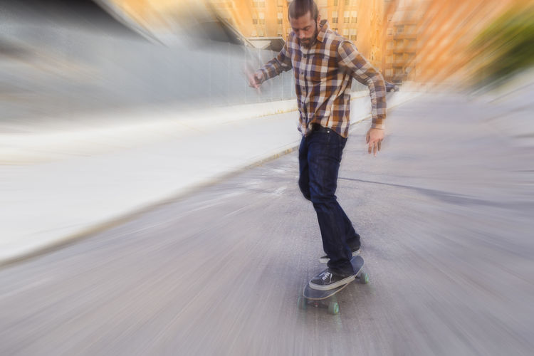 Urban man skateboarding in the city, reative motion blur shooting