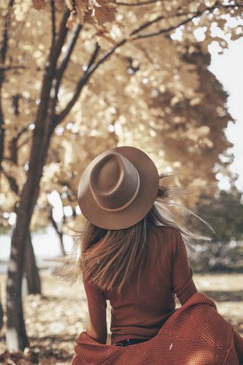 Rear view of woman wearing hat against trees