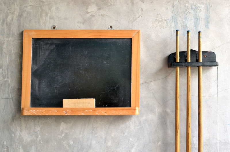 Blackboard and pool cues on wall