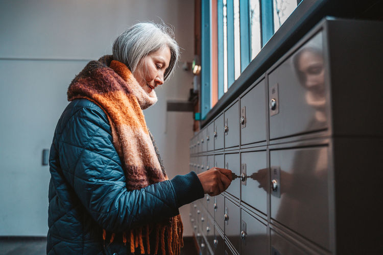 Side view of woman locking locker