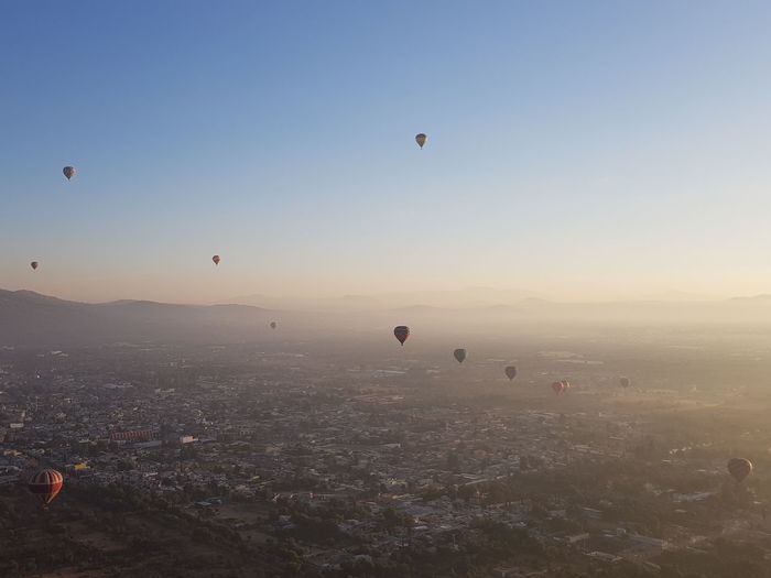 Hot air balloons flying in city