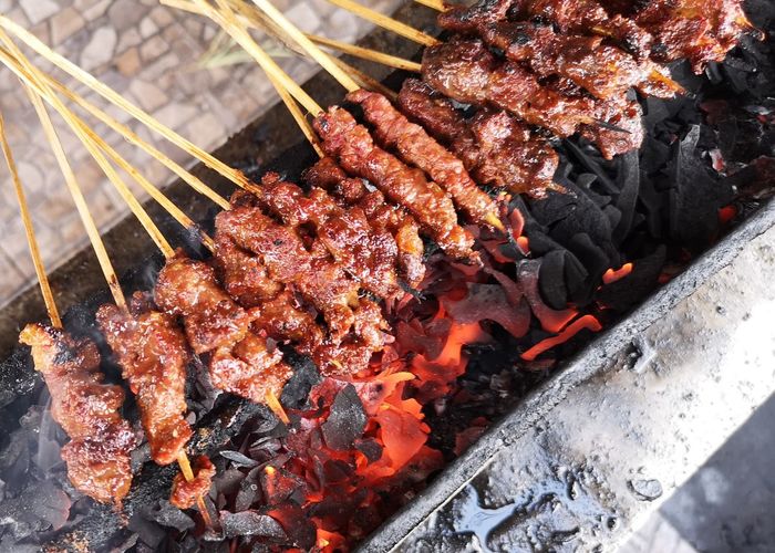 High angle view of beef satay on barbecue grill