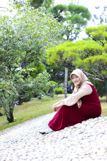 Portrait of smiling young woman sitting outdoors
