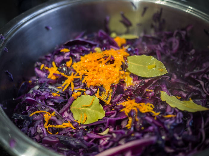 High angle view of red cabbage with lemon zest and bay leaves cooking in saucepan