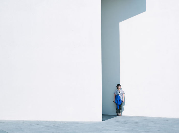 Man standing against white wall
