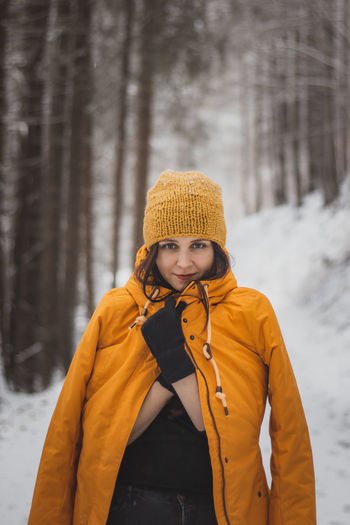 Young woman wearing hat standing on snow covered land