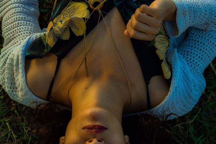 Midsection of woman lying on grass