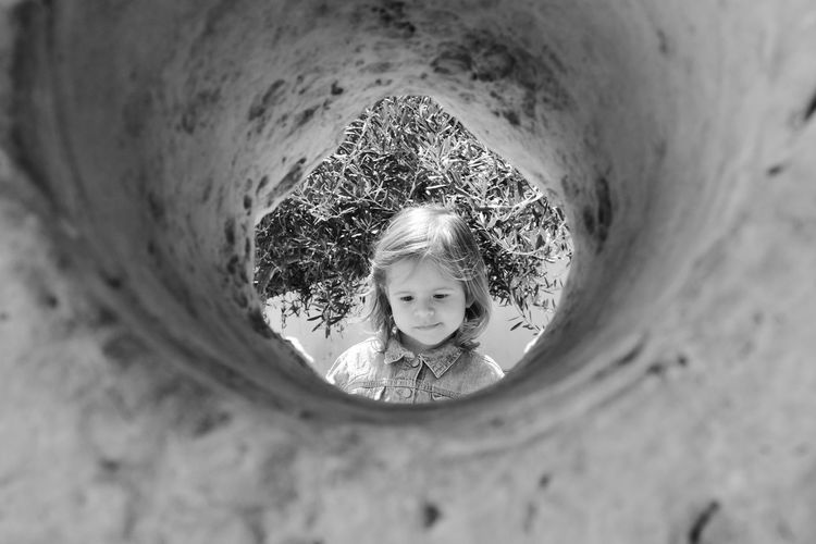 Cute girl looking down seen through hole