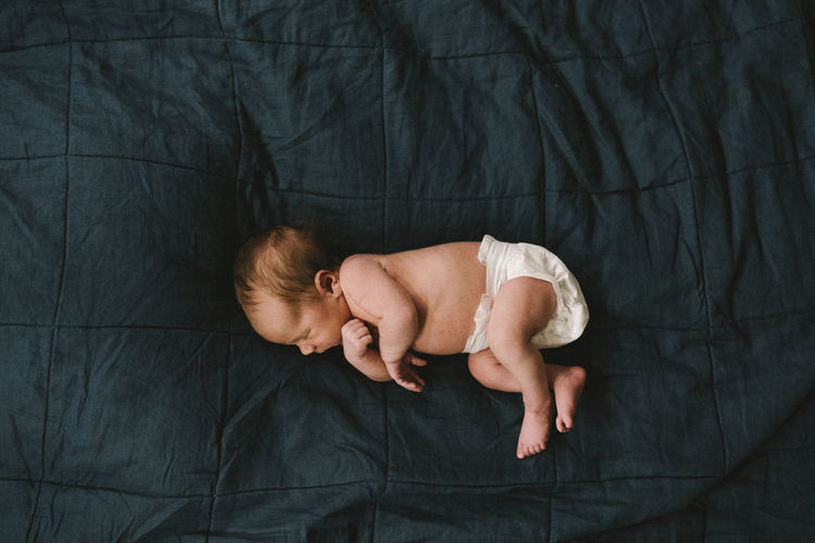 High angle view of baby sleeping on bed
