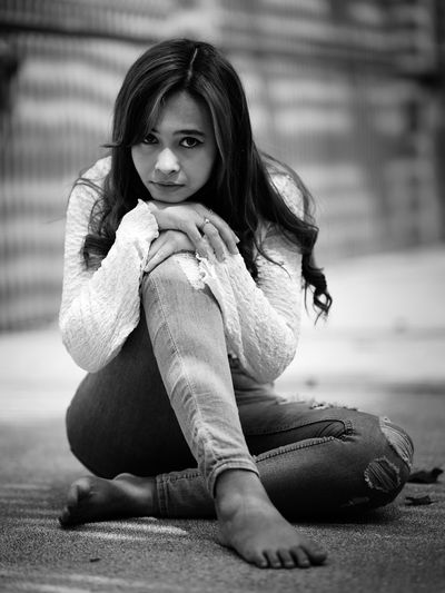 Portrait of young woman sitting on floor