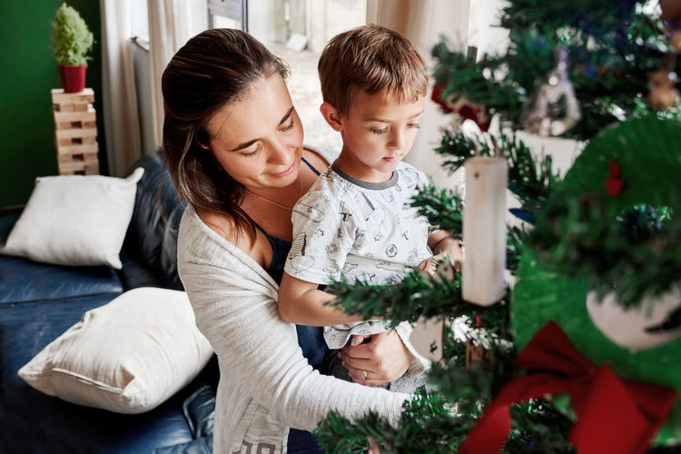 Mother helping son in decorating christmas tree