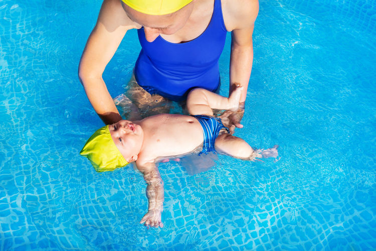 Midsection of woman with son in swimming