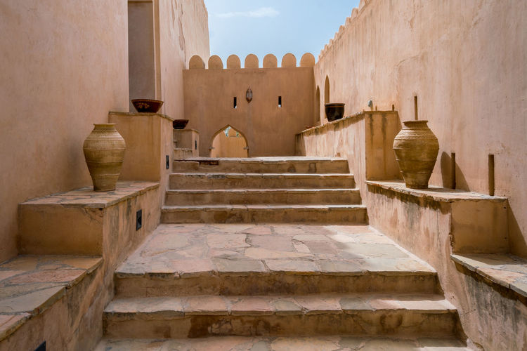 Alley in a medieval arabian fort with stairs and amphoras on each side. 