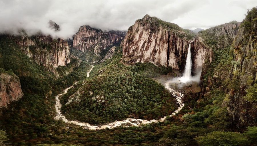 Scenic view of waterfall against sky