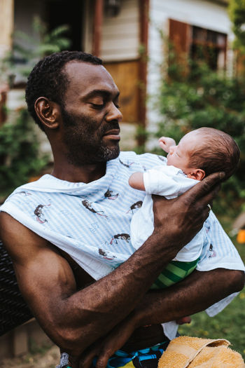 black man holding his baby boy Baby Emotions Family Fatherhood Moments Love Proud Relationship Black Caring Child Emotional Father Father & Son Fatherhood Holding Joy Lifestyles Newborn Outdoors Pride Protection Safety Smile Son Summer