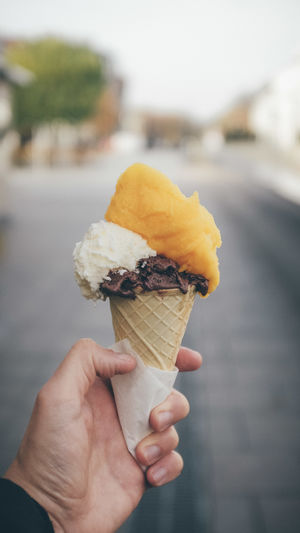 Close-up of hand having ice cream cone in city